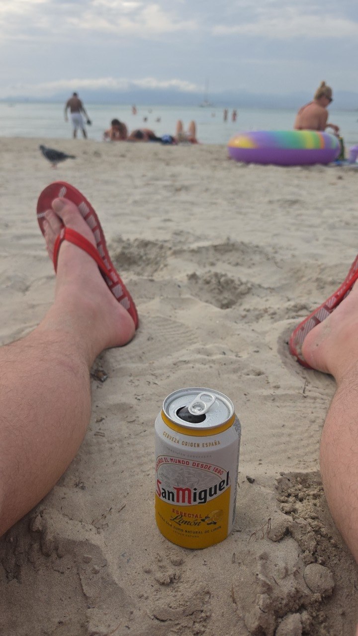 Johanizzle am Strand während der Full Metal Cruise auf der Mein Schiff 6 mit einer Dose San Miguel Limón